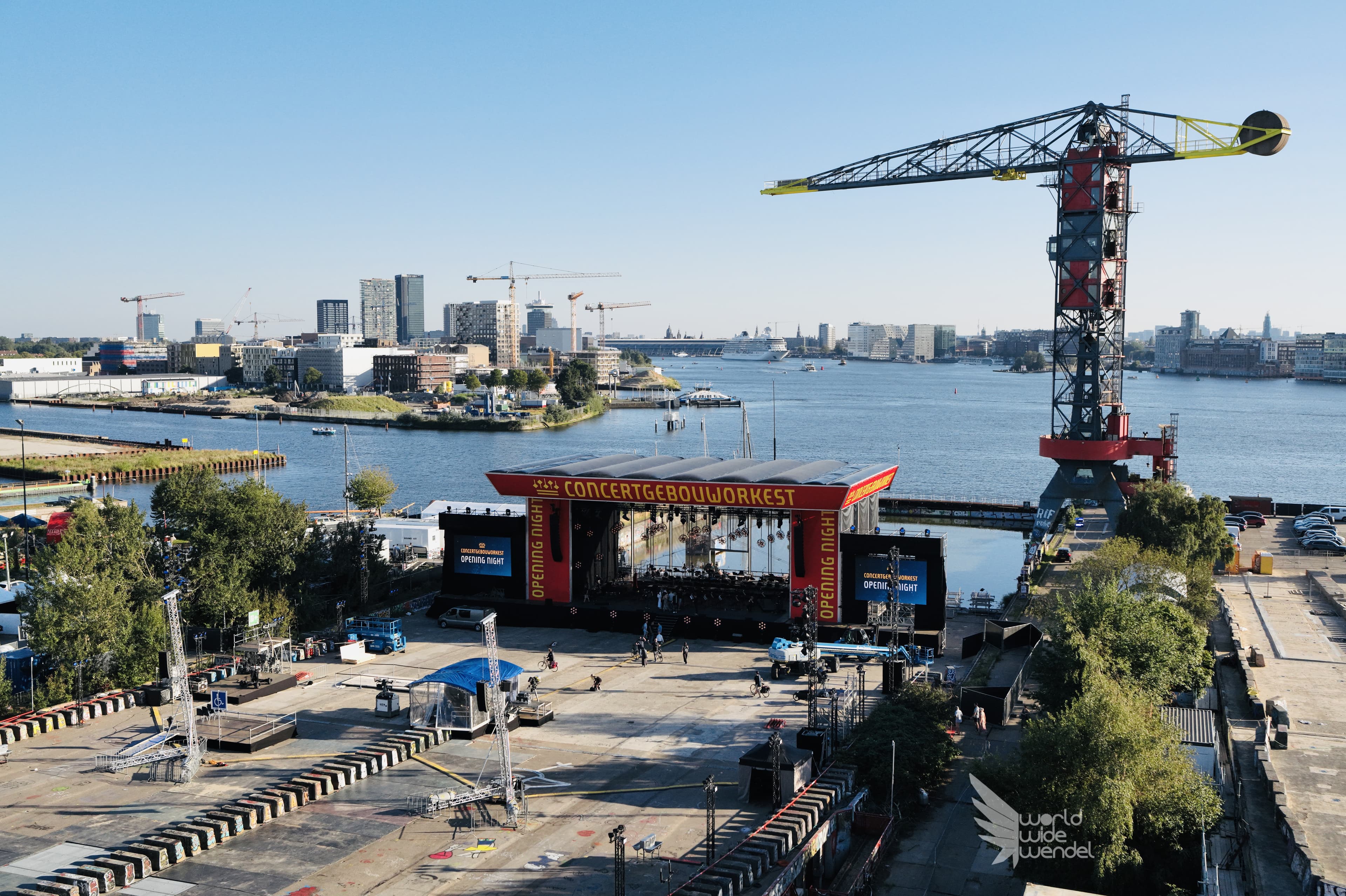 Luchtfoto van een concertpodium en bouwkraan aan het IJ in Amsterdam