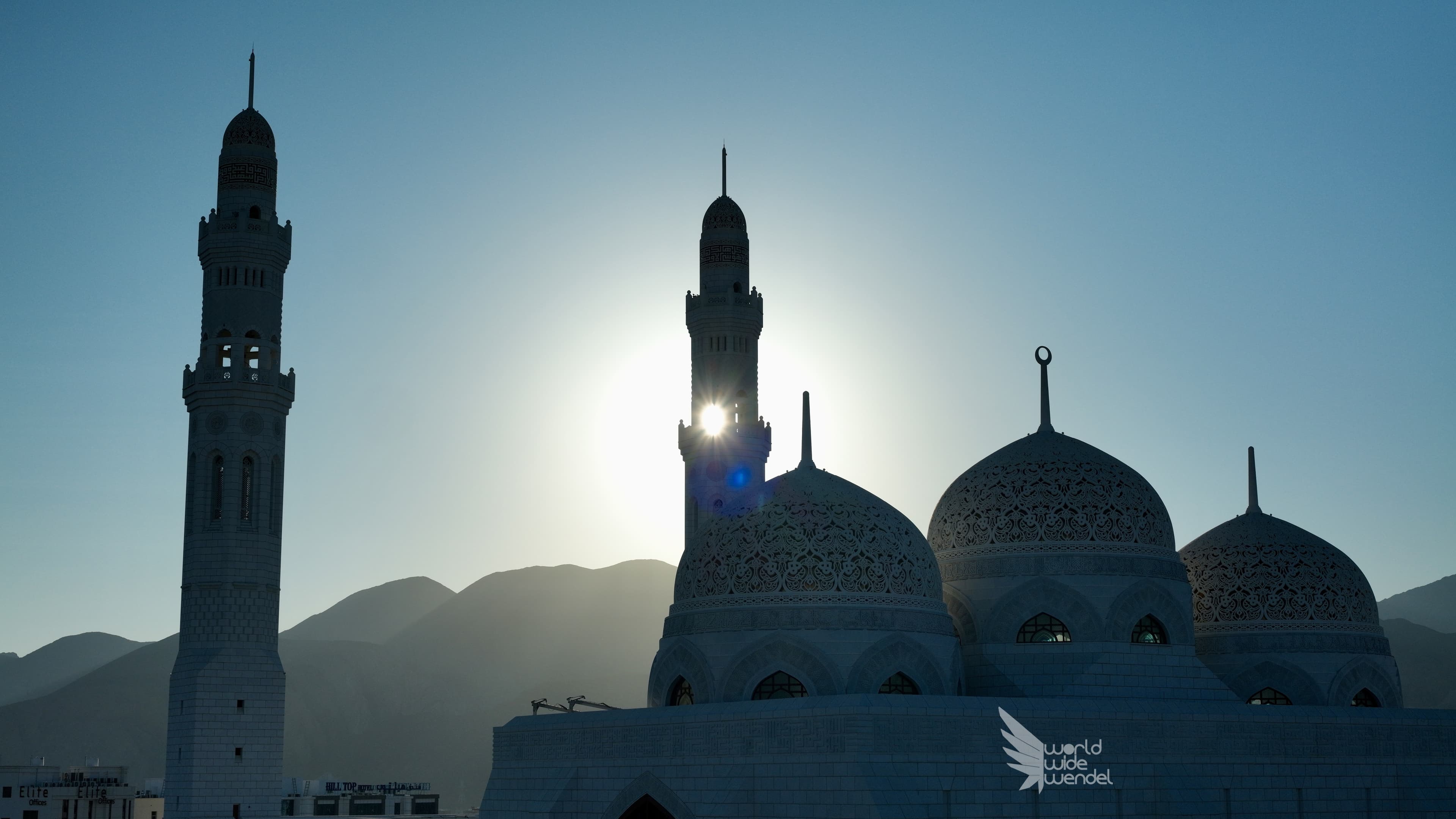 Minaretten van een moskee in tegenlicht bij zonsondergang, Oman