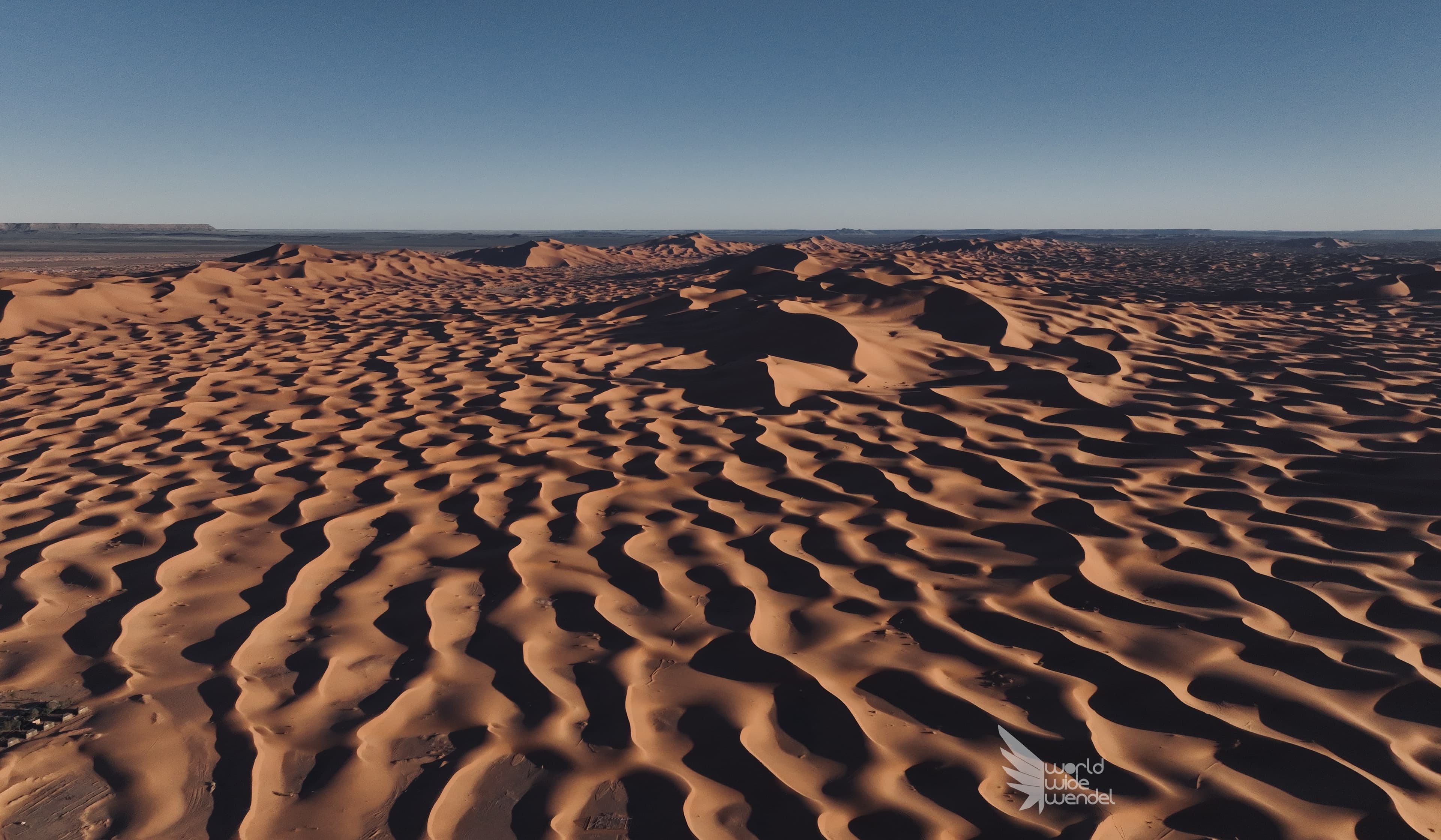 Luchtfoto van golvende zandduinen in de Sahara