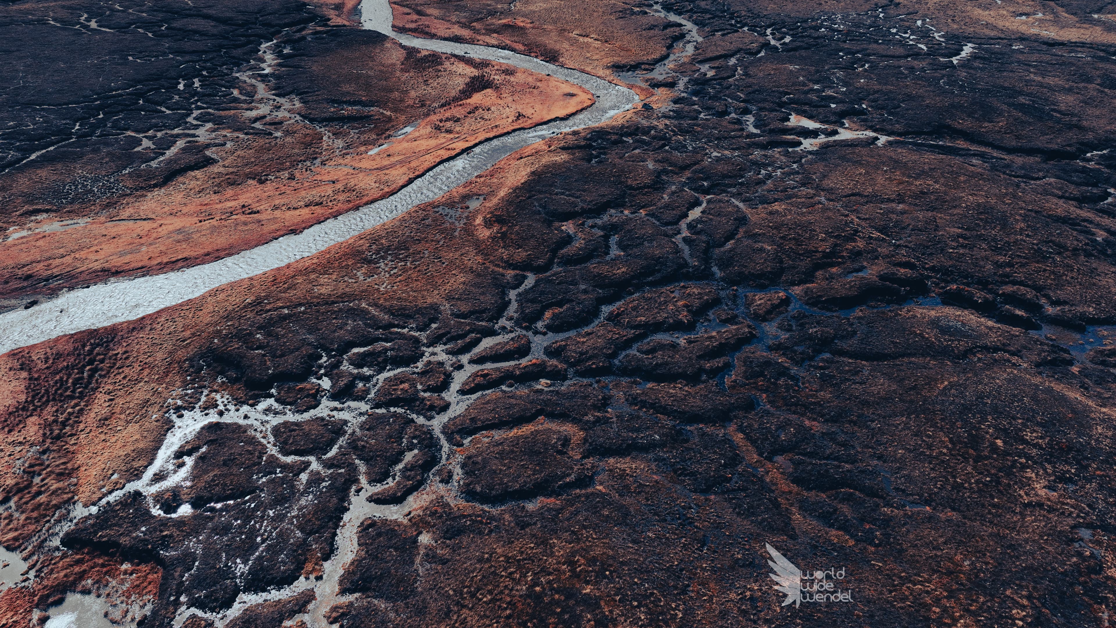 Luchtfoto van een rood zandlandschap met vertakte kreken