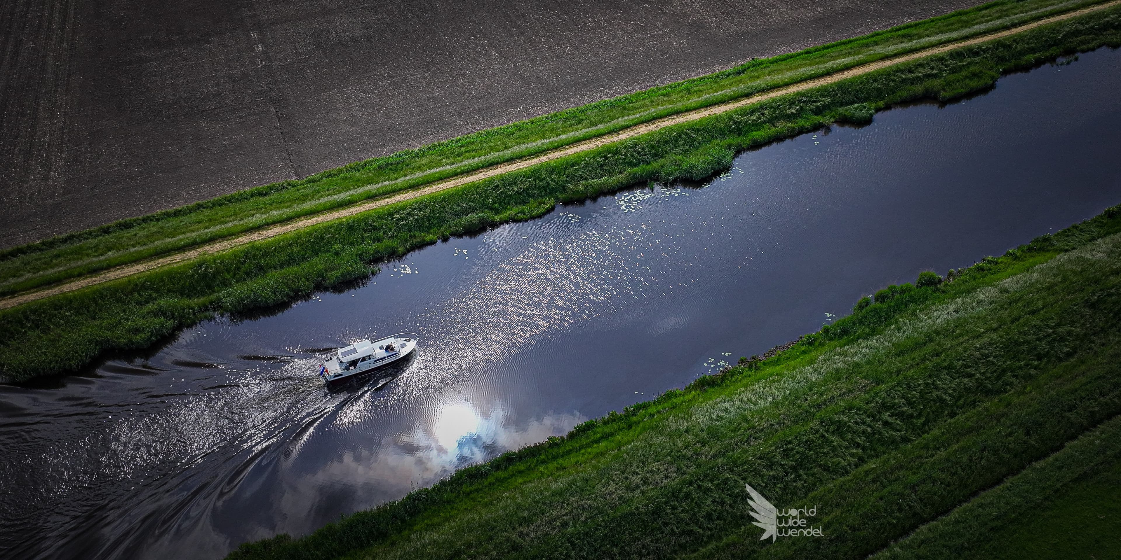 Luchtfoto van een catamaran bij een groen mangrove-eilandje in turkoois water